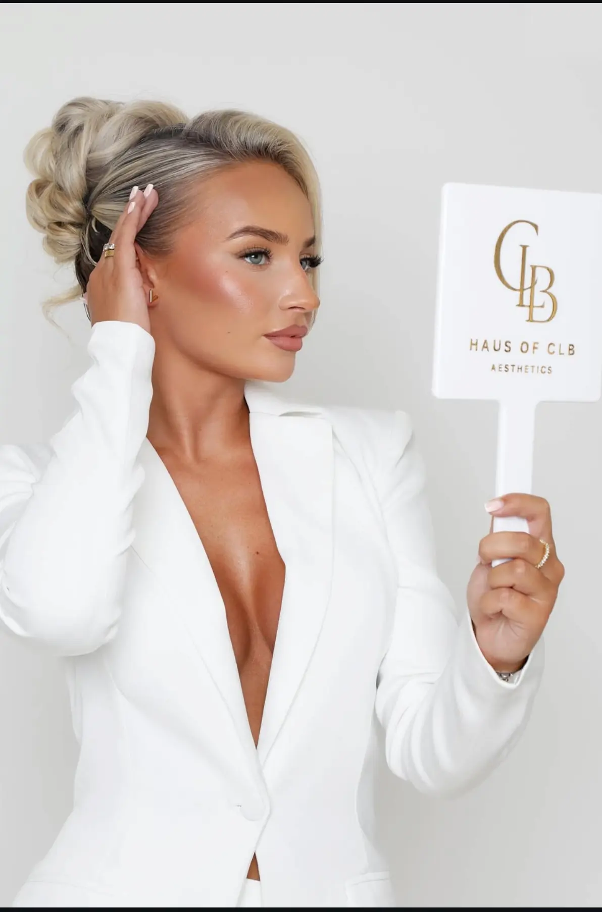 Nurse Charlotte, founder of Haus of CLB, holding the clinic's monogram